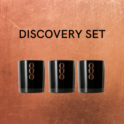 Discovery set title. Scratched bronze background with three small candles. Gloss black glass jars with bronze Ode logo 